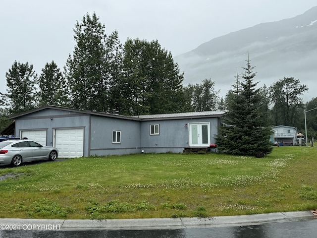 view of front of house with a mountain view and a front lawn