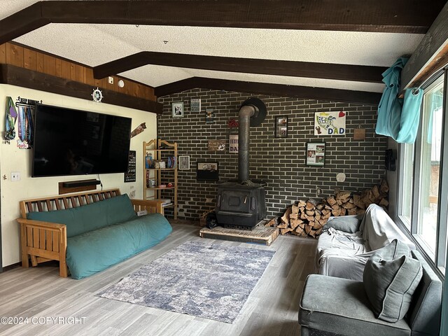 living room with plenty of natural light, brick wall, and a wood stove