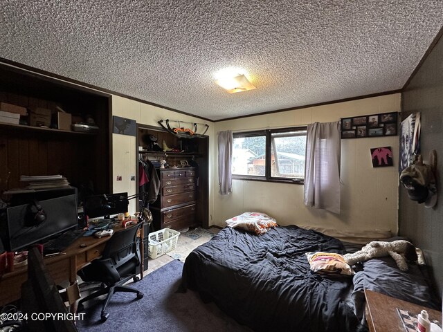 bedroom with a closet, light colored carpet, and a textured ceiling