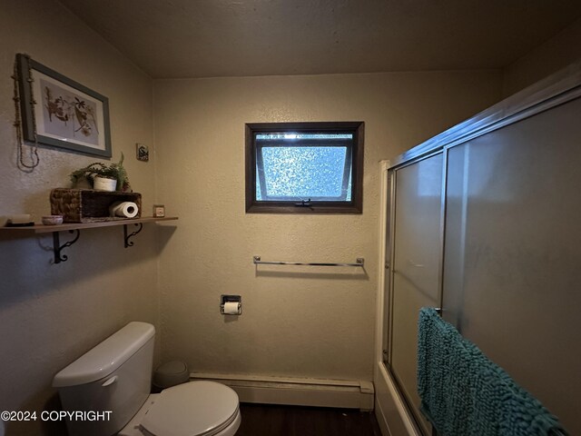 bathroom with combined bath / shower with glass door, toilet, wood-type flooring, and a baseboard radiator