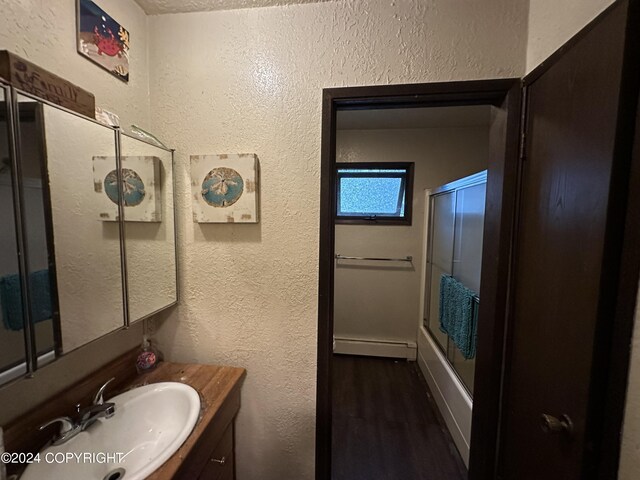 bathroom with hardwood / wood-style floors, a baseboard heating unit, and vanity