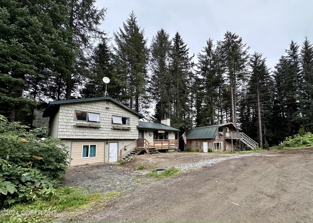 view of front of property featuring a wooden deck and an outbuilding