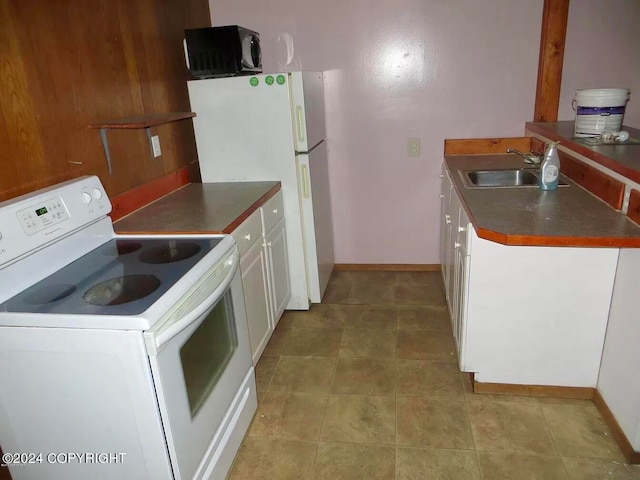 kitchen featuring wood walls, sink, white cabinetry, white appliances, and light tile patterned floors