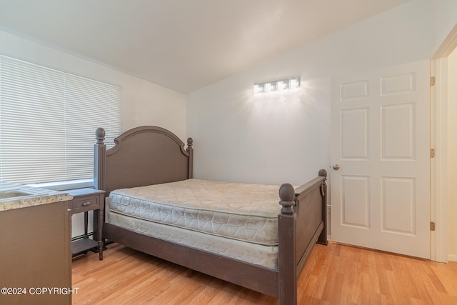 bedroom with lofted ceiling and light hardwood / wood-style flooring