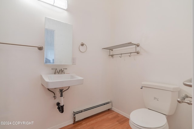 bathroom featuring hardwood / wood-style floors, sink, toilet, and baseboard heating