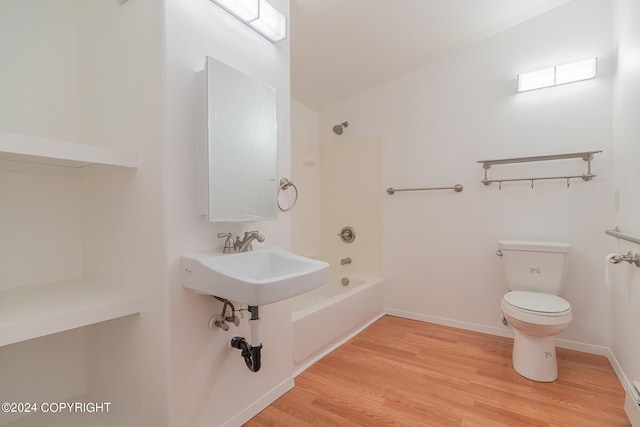 bathroom with hardwood / wood-style flooring, washtub / shower combination, a baseboard heating unit, vaulted ceiling, and toilet