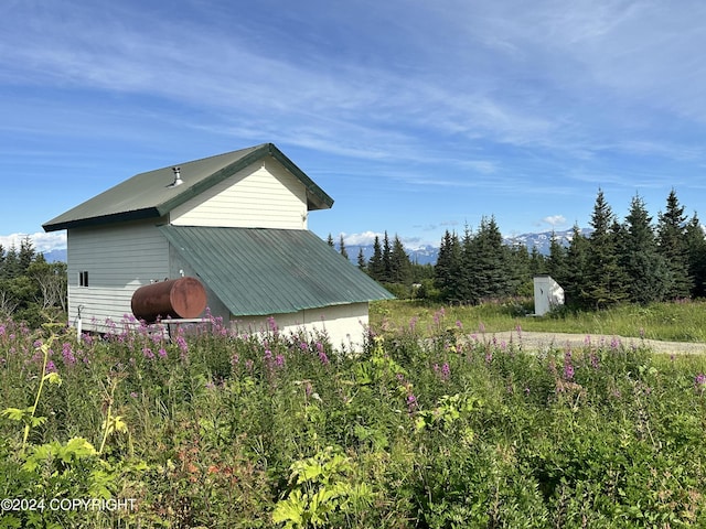 view of side of home with metal roof and an outdoor structure