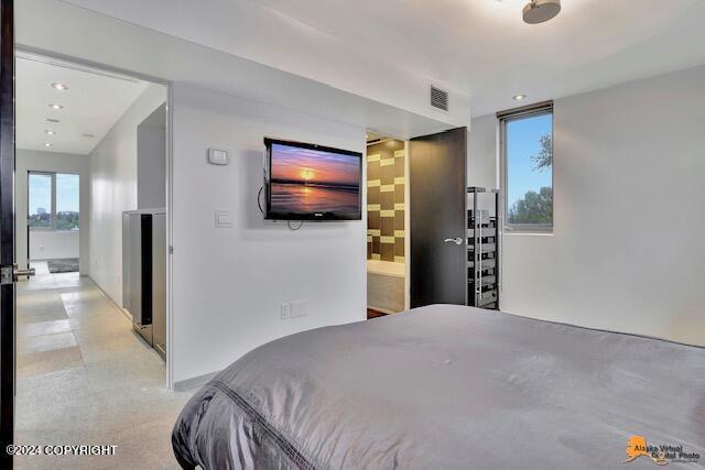 bedroom with connected bathroom, visible vents, and recessed lighting