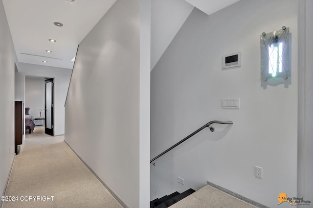 hall with an upstairs landing, baseboards, and recessed lighting