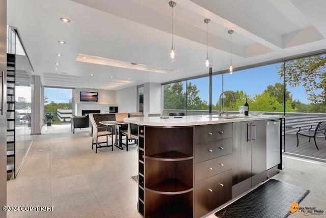 kitchen featuring a fireplace, a sink, light countertops, open shelves, and modern cabinets