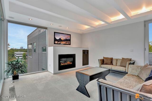 living room featuring recessed lighting, beamed ceiling, carpet flooring, and a glass covered fireplace