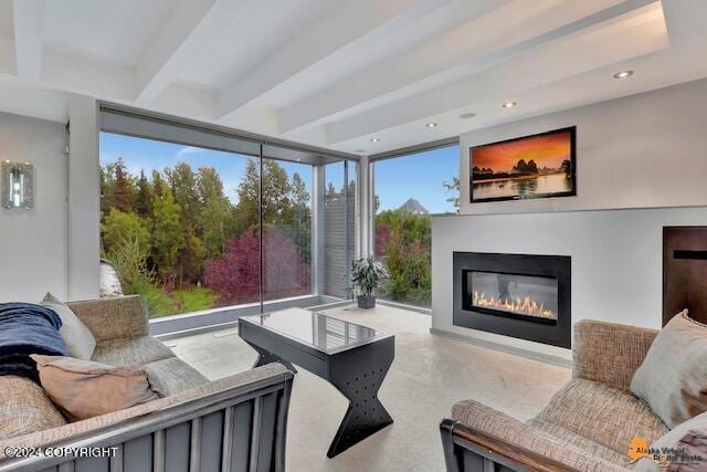 living room featuring a glass covered fireplace, beam ceiling, and recessed lighting