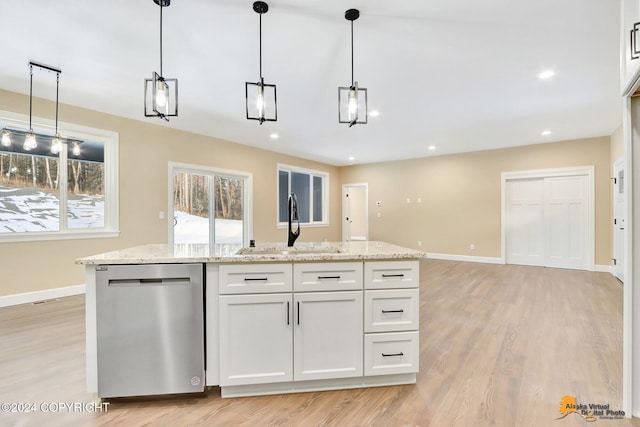 kitchen with stainless steel dishwasher, decorative light fixtures, sink, and white cabinets