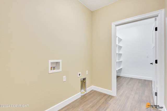 clothes washing area with electric dryer hookup, washer hookup, and light wood-type flooring