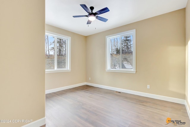 empty room with ceiling fan and light hardwood / wood-style flooring