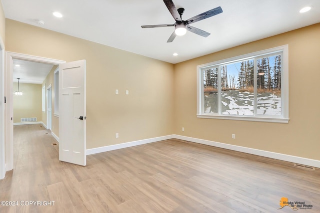 spare room with ceiling fan and light wood-type flooring