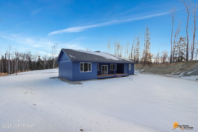 view of snow covered back of property