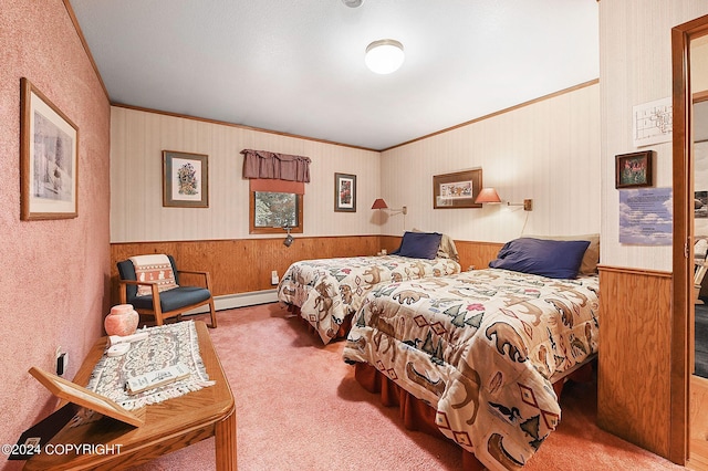 carpeted bedroom featuring crown molding, a baseboard heating unit, and wooden walls