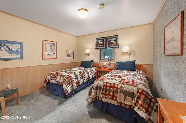 carpeted bedroom featuring ornamental molding and wooden walls