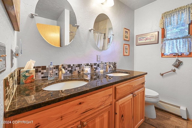 bathroom with hardwood / wood-style floors, tasteful backsplash, a baseboard radiator, toilet, and vanity