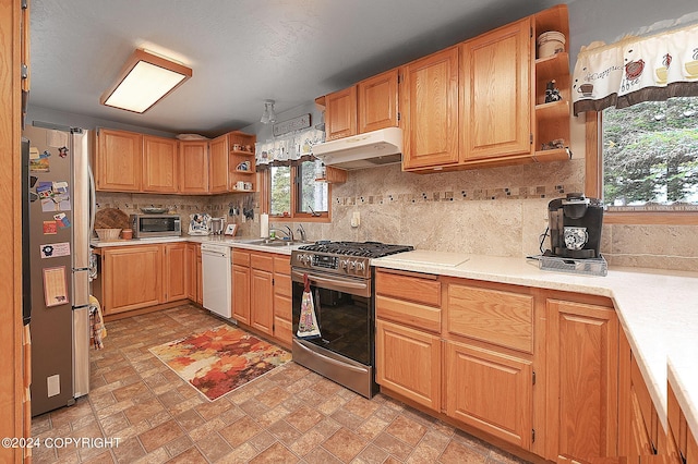 kitchen featuring appliances with stainless steel finishes, sink, and backsplash