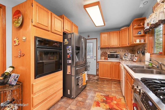 kitchen with sink, stainless steel appliances, and tasteful backsplash