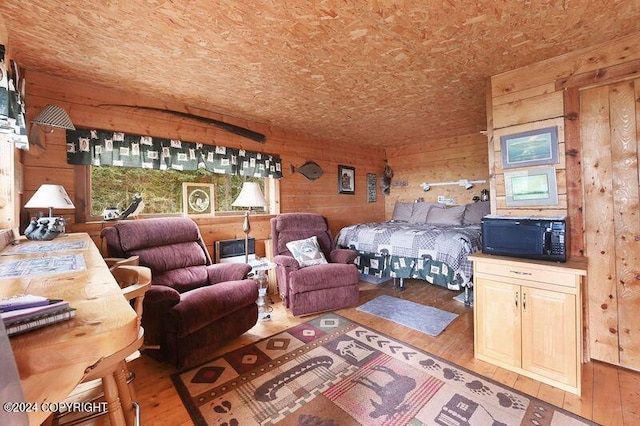 bedroom with wooden walls and light wood-type flooring