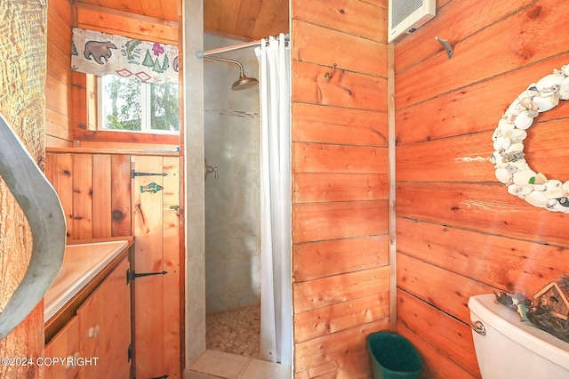 bathroom with vanity, toilet, wood walls, and a shower with curtain