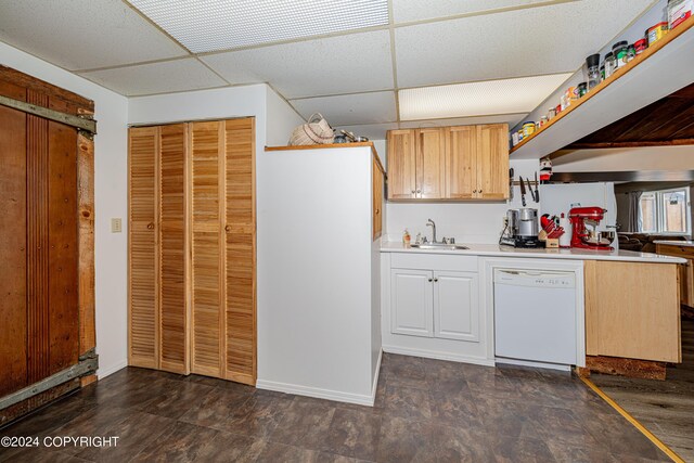 kitchen featuring a paneled ceiling, white dishwasher, sink, and light brown cabinets