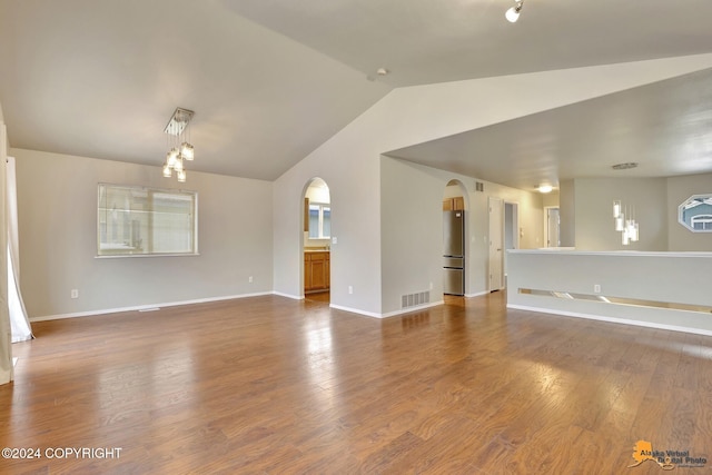 unfurnished living room with dark hardwood / wood-style floors and vaulted ceiling