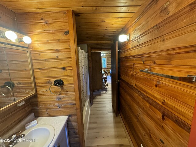 bathroom with wooden walls, wooden ceiling, vanity, and hardwood / wood-style floors