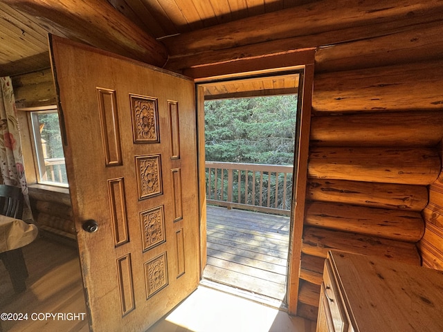 doorway to outside featuring log walls, light hardwood / wood-style floors, a wealth of natural light, and wood ceiling