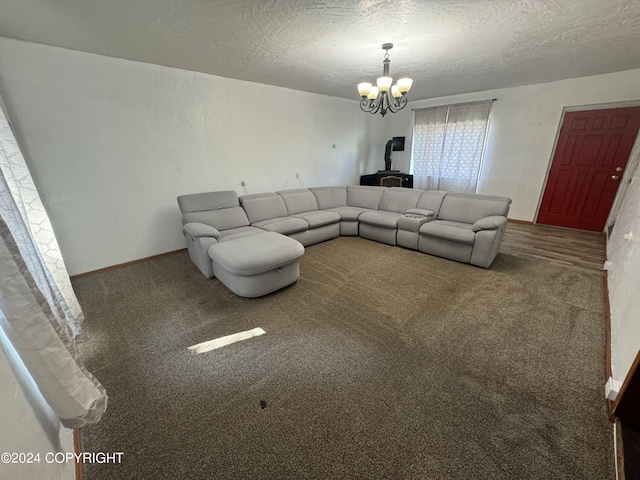 unfurnished living room with a textured ceiling, carpet flooring, and a chandelier