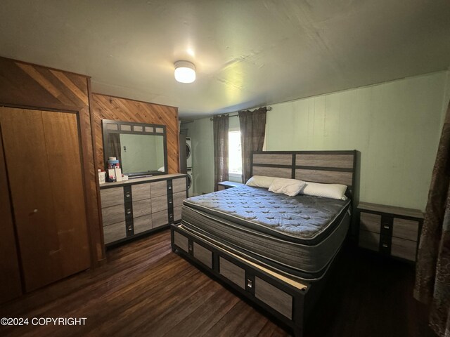 bedroom with wood walls and dark hardwood / wood-style floors