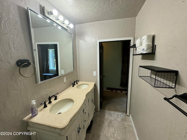 bathroom featuring tile patterned flooring, a textured ceiling, and vanity