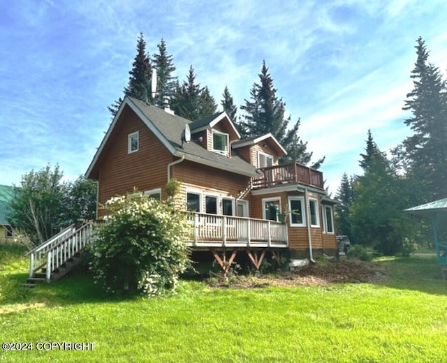 rear view of house featuring a yard and a deck