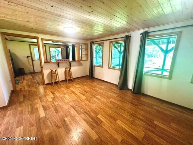 unfurnished room featuring a wealth of natural light, hardwood / wood-style floors, and wooden ceiling