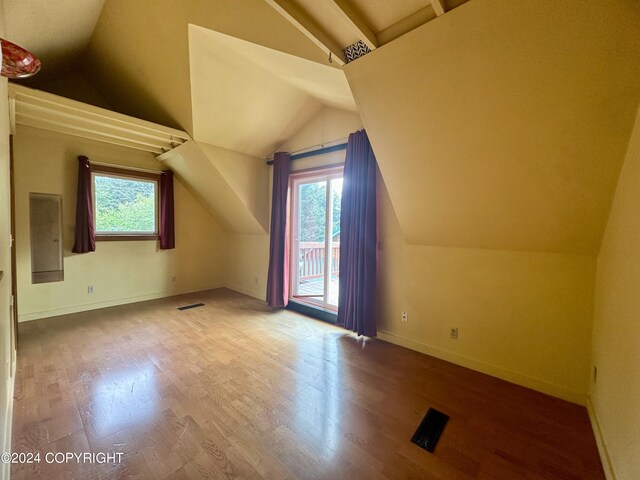 additional living space featuring hardwood / wood-style floors and vaulted ceiling