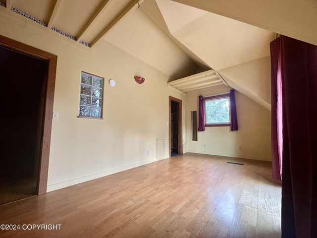 bonus room featuring lofted ceiling with beams and wood-type flooring