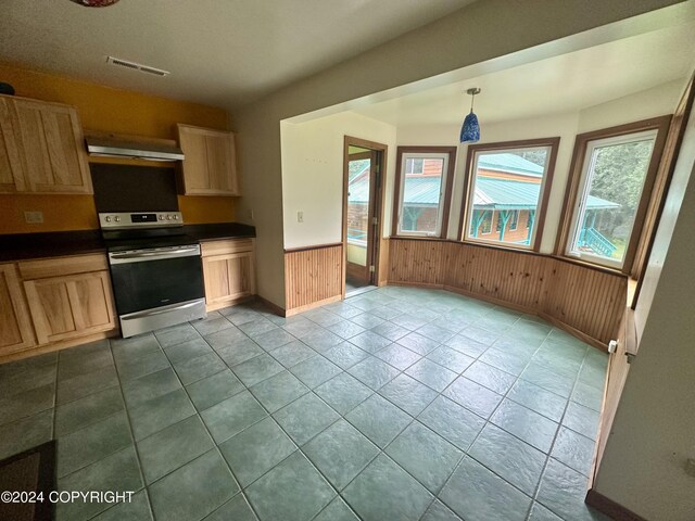 kitchen featuring wood walls, range hood, hanging light fixtures, electric range, and light brown cabinets