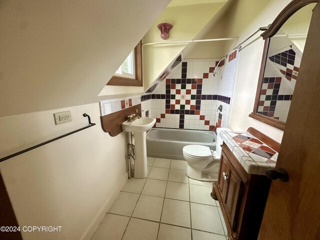 bathroom featuring tiled shower / bath combo, toilet, and tile patterned floors