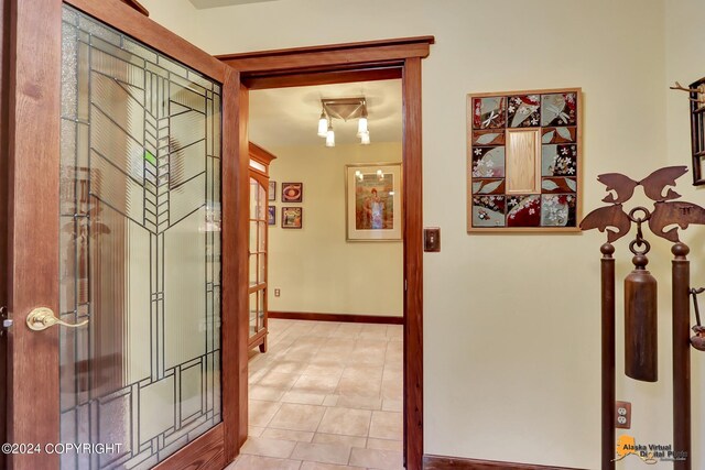 corridor with french doors and light tile patterned floors