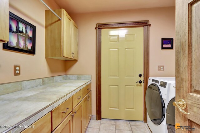 washroom featuring cabinets, independent washer and dryer, and light tile patterned floors