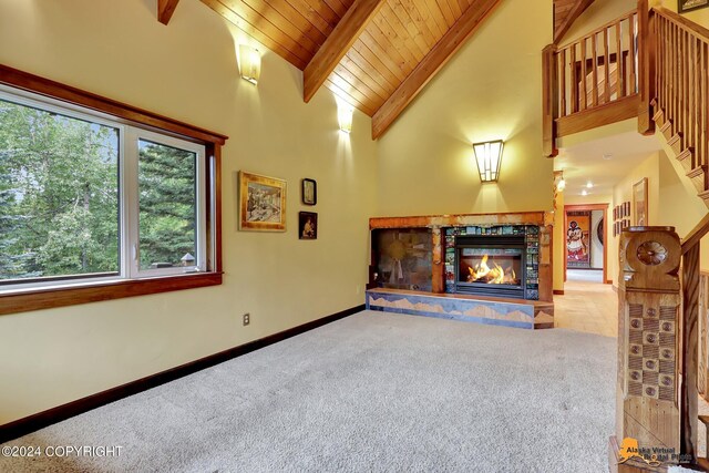 living room featuring high vaulted ceiling, a fireplace, wood ceiling, and carpet floors