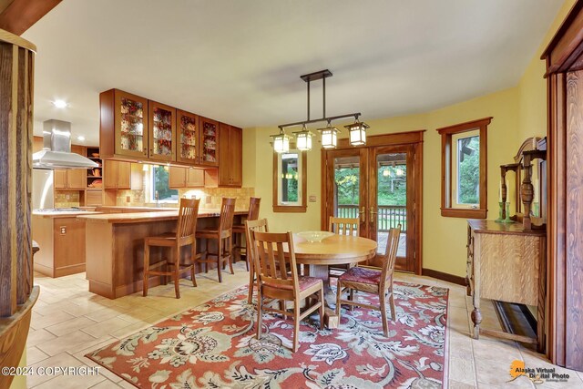 tiled dining space featuring french doors and plenty of natural light