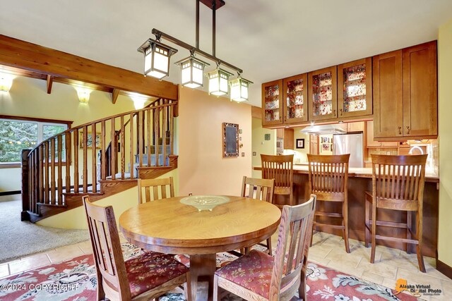 tiled dining space with beamed ceiling