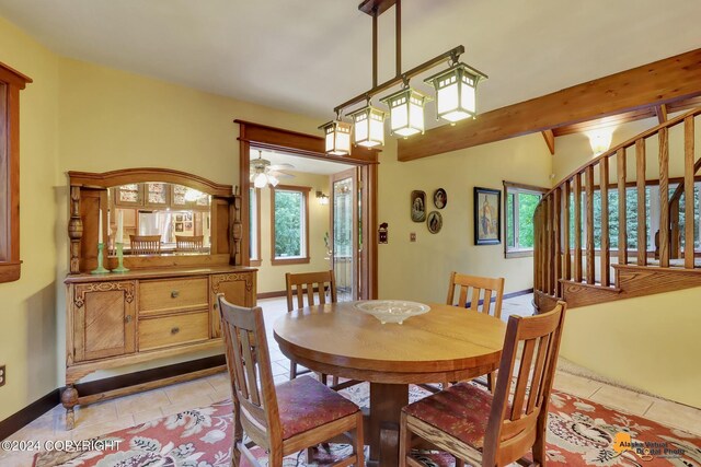 tiled dining space featuring ceiling fan and beam ceiling