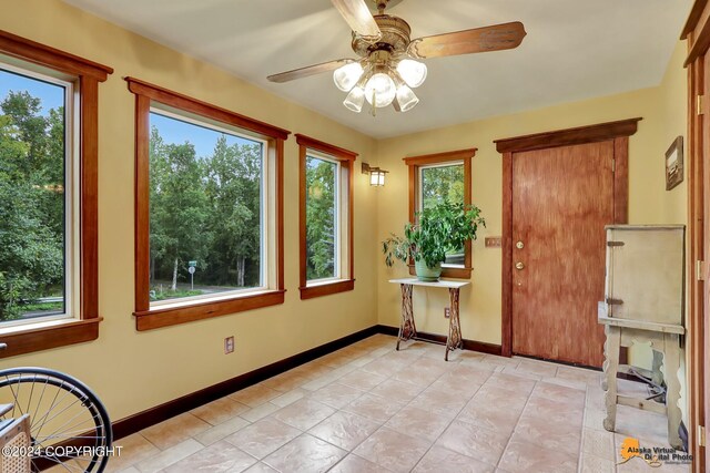 unfurnished sunroom featuring ceiling fan