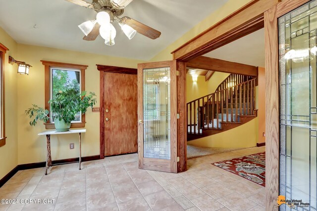 foyer entrance with light tile patterned floors and ceiling fan