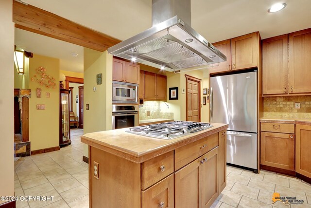 kitchen with island range hood, backsplash, appliances with stainless steel finishes, and a center island